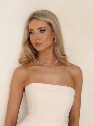 Model wearing the Aurora Necklace, 14k gold plated with pear drop stones, styled for a bridal look