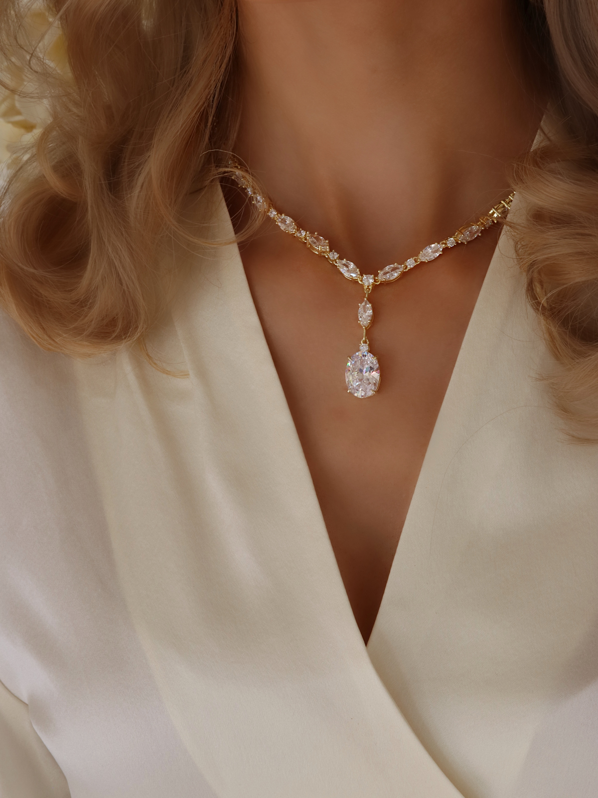 Model wearing the gold Bridget necklace with oval cut cubic zirconia drop, styled as elegant bridal jewellery
