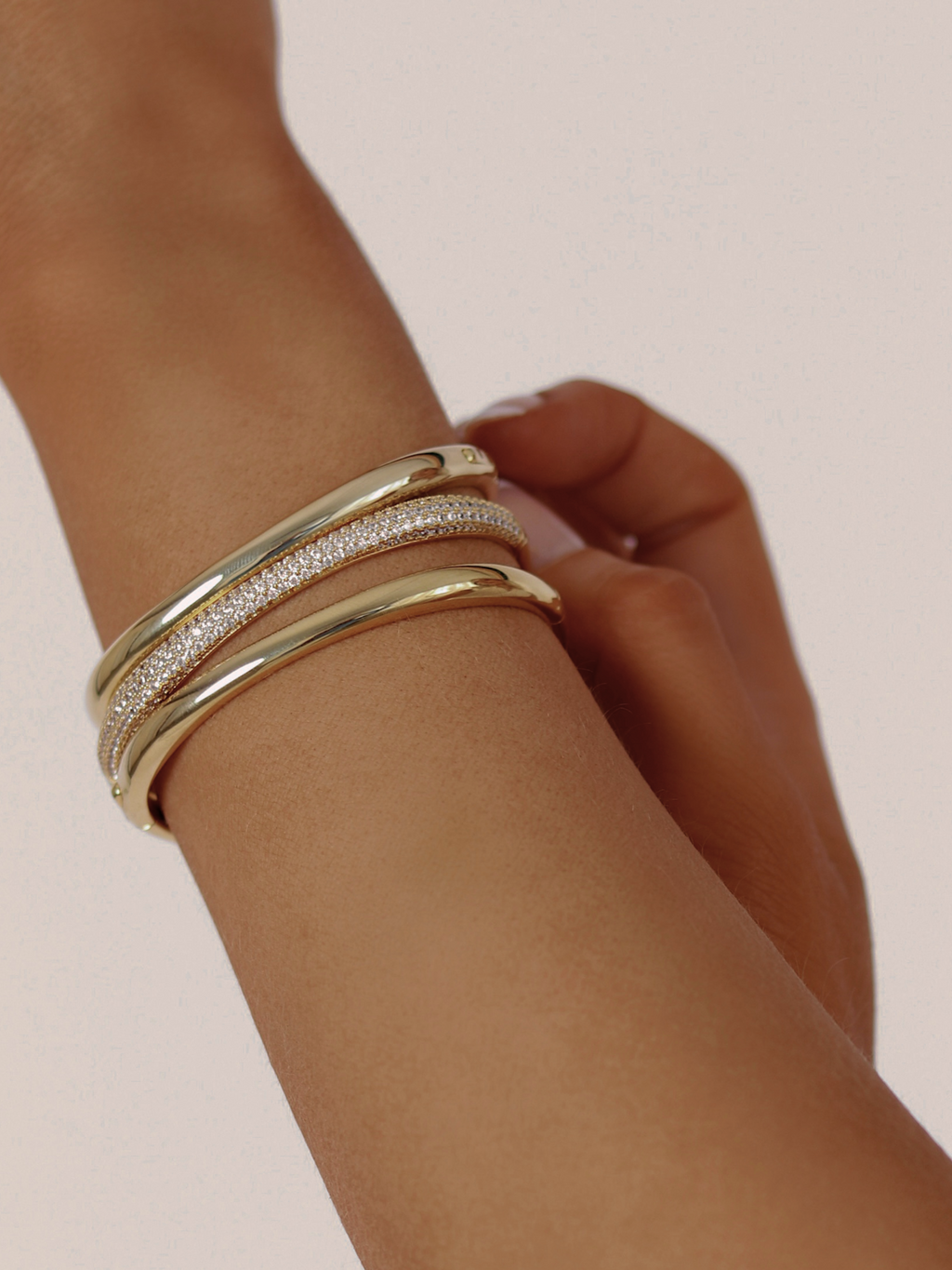 Christy pavé bangle in gold styled with two smooth gold Christy bangles, worn stacked on wrist