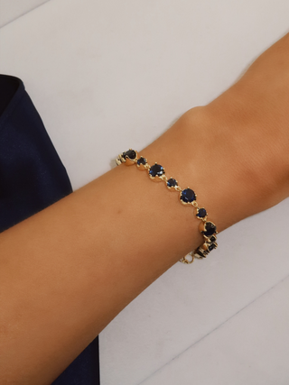 Clarissa Bracelet in 14k gold plating with deep blue cubic zirconia stones, angled wrist view