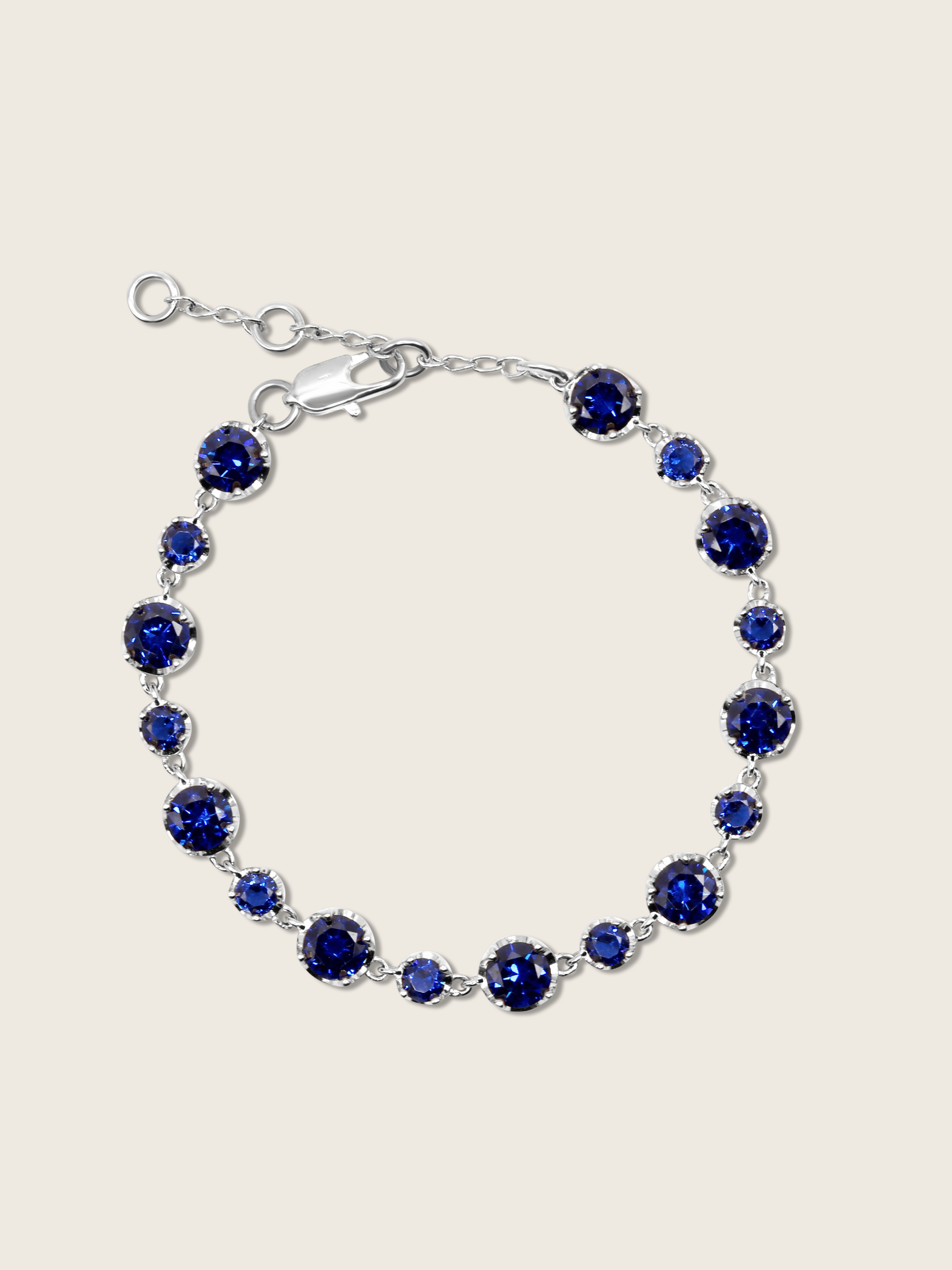 Clarissa white gold plated bracelet with round navy blue cubic zirconia stones in a graduated tennis design, elegant fine jewellery for women, shown on a white background.