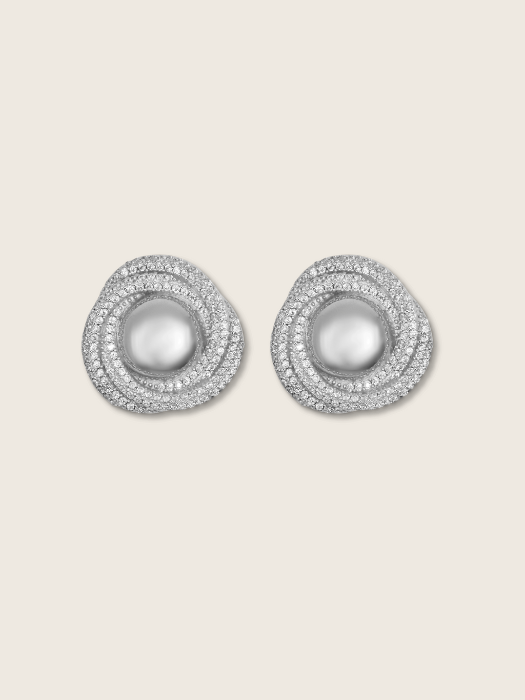 Pearl and CZ swirl earrings on neutral background, white gold plated