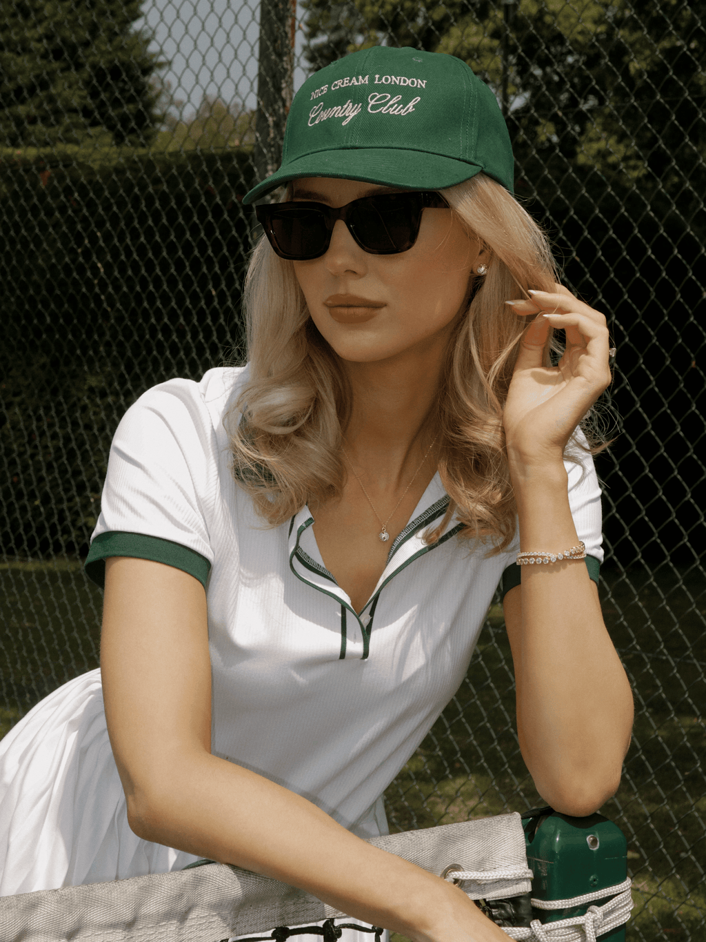 Tennis-inspired outfit featuring gold plated pavé stud earrings and matching pendant necklace styled courtside