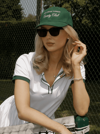 Tennis-inspired outfit featuring gold plated pavé stud earrings and matching pendant necklace styled courtside