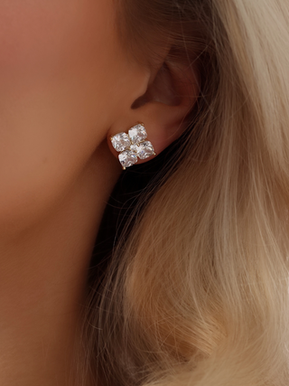 Close-up of a model wearing the Crystal Hydrangea Stud Earrings, showing the intricate floral arrangement of CZ stones in a gold-plated sterling silver setting.