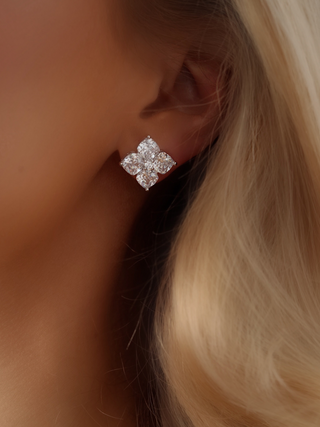 Close-up of a model wearing the Crystal Hydrangea Stud Earrings, showing the intricate floral arrangement of CZ stones in a white gold-plated sterling silver setting.