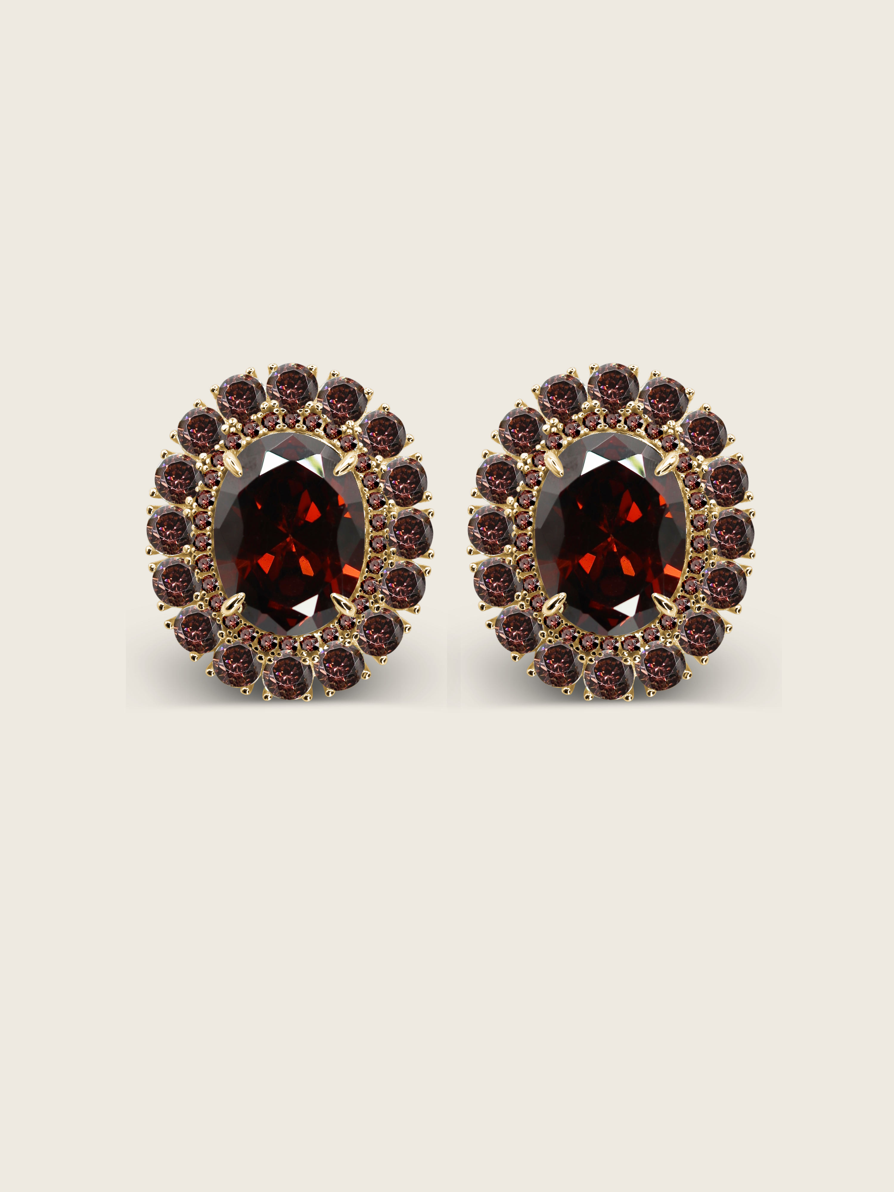 Diana earrings with wine cubic zirconia stones set in an oval gold frame, shown on a neutral background