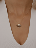 Gold plated Florence necklace worn on model. Shiny hydrangea-shaped pendant on a fine chain, designed for elegant minimalist styling.