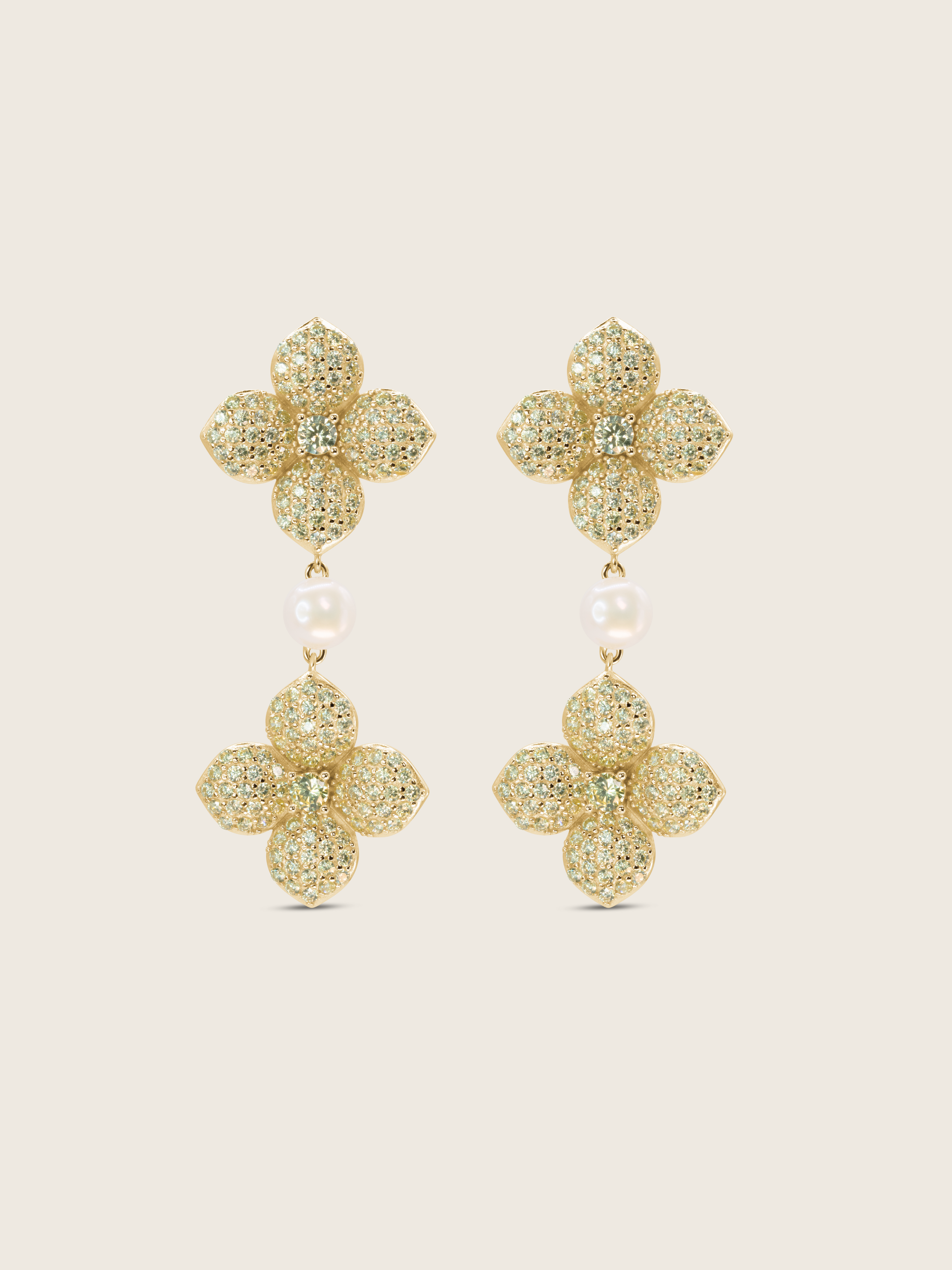 Gold plated hydrangea dangle earrings with yellow cubic zirconia stones and freshwater pearl on white background. Floral statement earrings with sparkling finish.