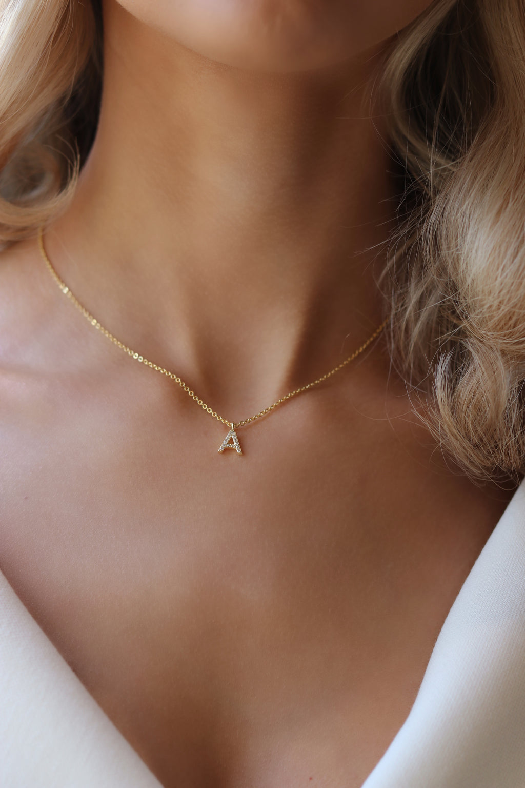 Gold plated Love Letter necklace with CZ-studded initial pendant, worn at the collarbone for a dainty, personal touch perfect for everyday layering