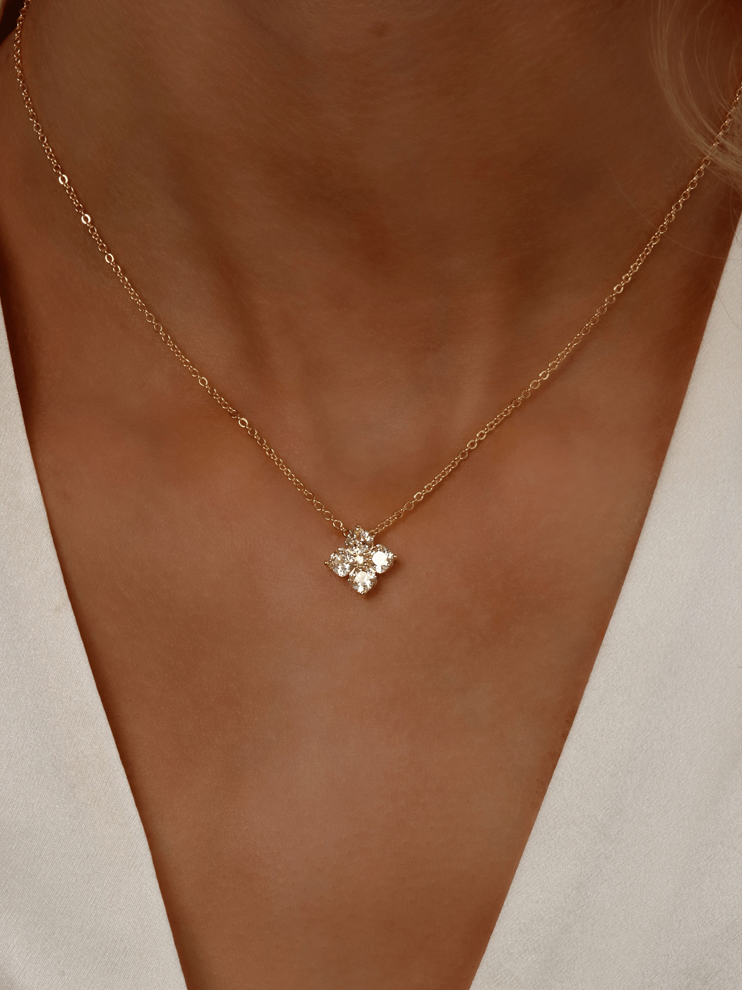 Close-up of model wearing Gold Mini Crystal Hydrangea Necklace in Lemon Drop, featuring a delicate yellow CZ flower pendant on the neckline