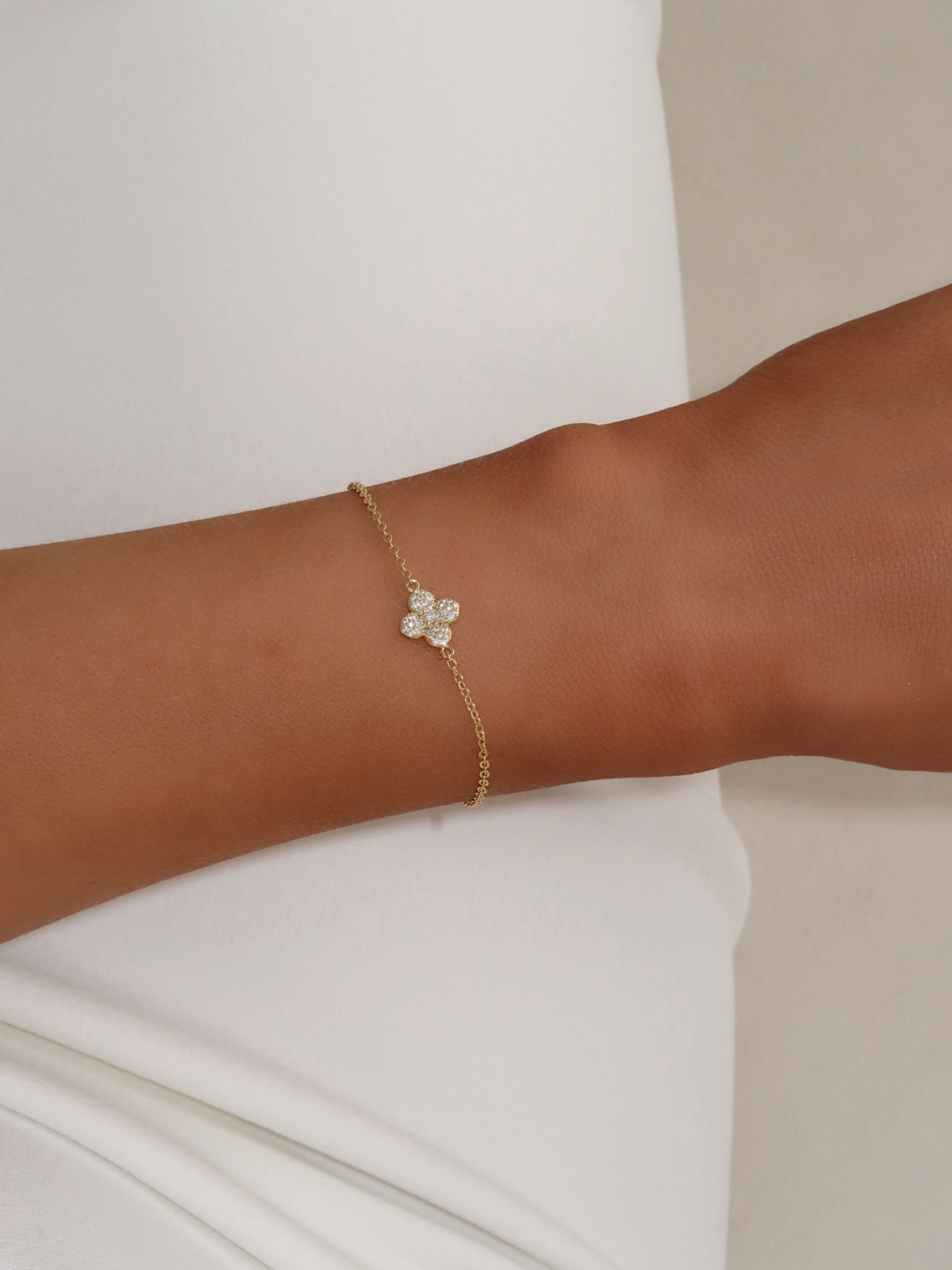 Close-up of gold plated Mini Hydrangea bracelet with cubic zirconia flower charm worn on wrist