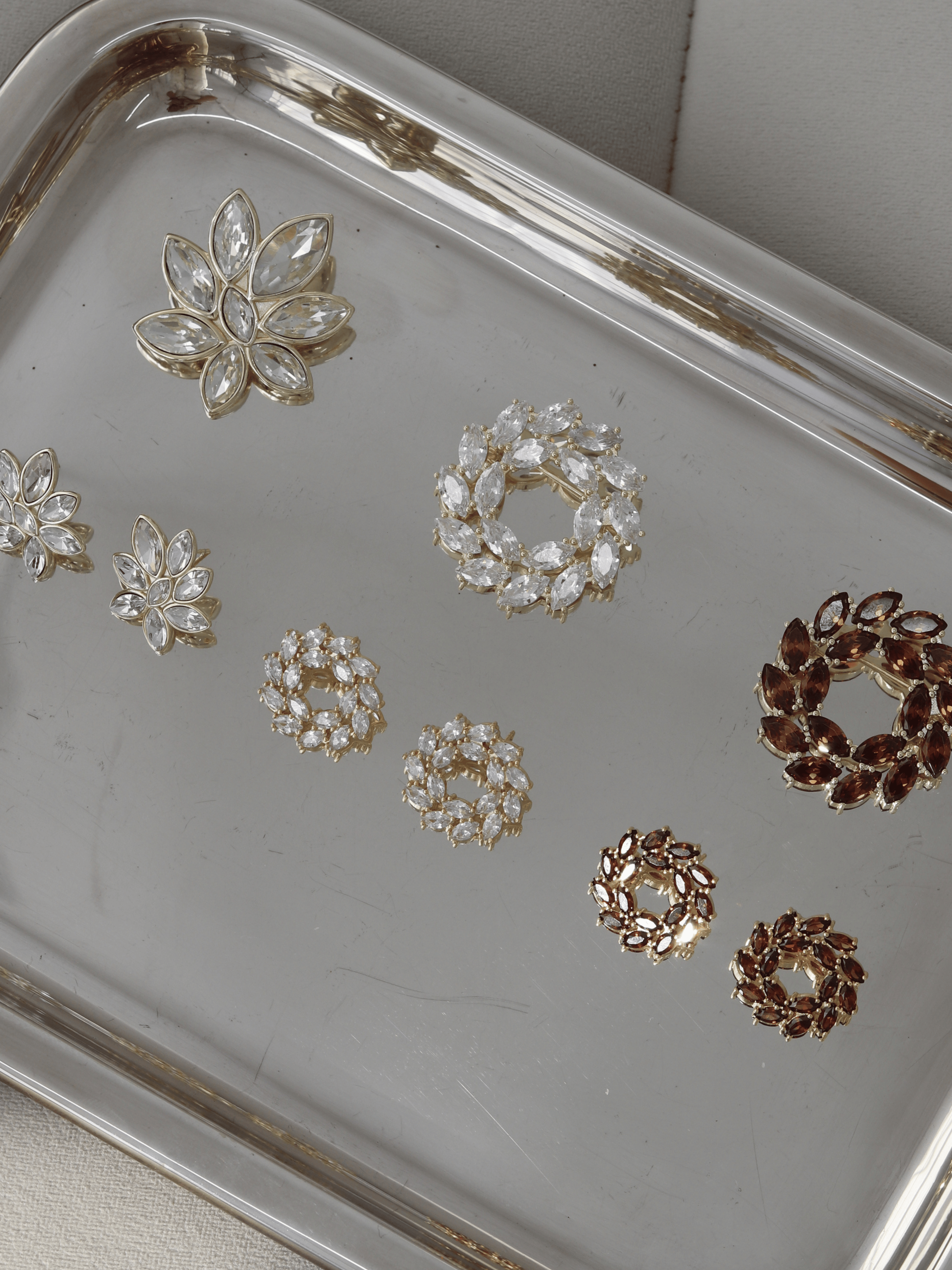 Iris Brooch in 14k gold plating with clear marquise cut cubic zirconia stones displayed on tray alongside Amanda Brooch, Iris Earrings and Amanda Earrings
