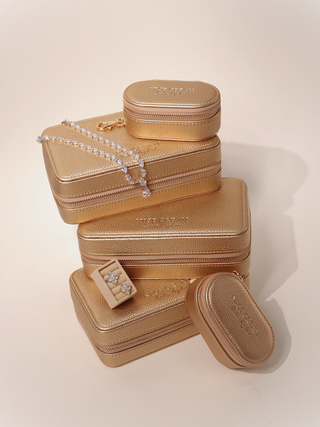 Stacked champagne jewellery cases in small and large sizes with Aurora necklace and earring insert displayed on top.