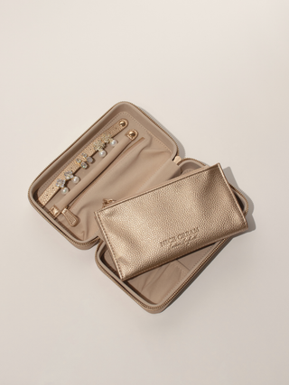 Large champagne jewellery case open showing earring holder and compartments, with matching travel insert placed across the case.