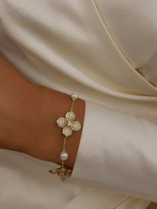 Lemon Drop Hydrangea bracelet with 14k Gold plating on model’s wrist, showing lemon CZ flower and freshwater pearls along a fine adjustable chain