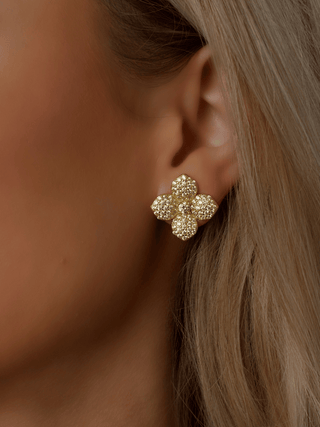 Lemon Drop Hydrangea stud earrings in a model's ear with 14k Gold plating, detailed with lemon CZ stones in a symmetrical flower shape