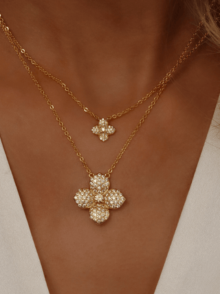 Model showing stacked Lemon Drop necklaces in 14k Gold plating, with the mini and classic lemon CZ flower pendants layered on the neckline
