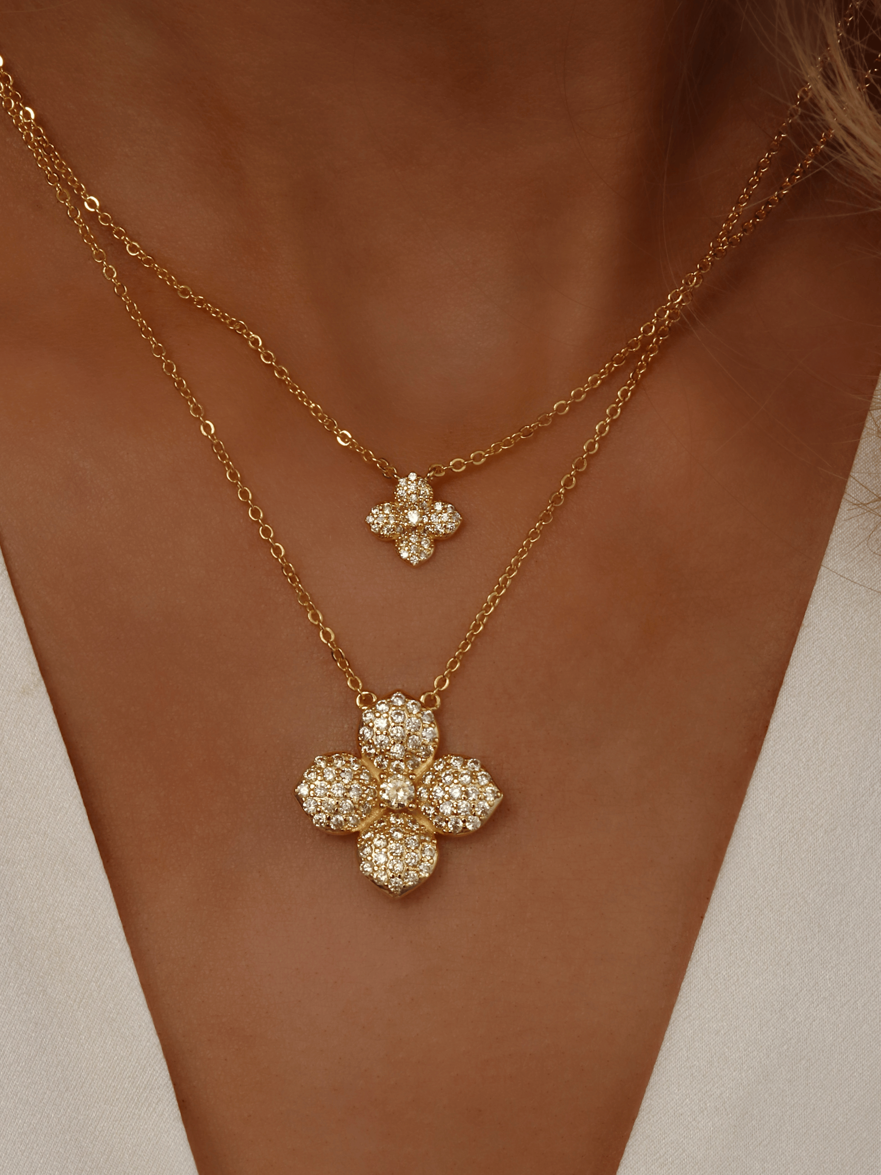 Model showing stacked Lemon Drop necklaces in 14k Gold plating, with the mini and classic lemon CZ flower pendants layered on the neckline