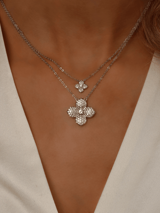 Model wearing stacked Lemon Drop necklaces in premium White Gold plating, featuring the classic and mini floral pendants on layered chains