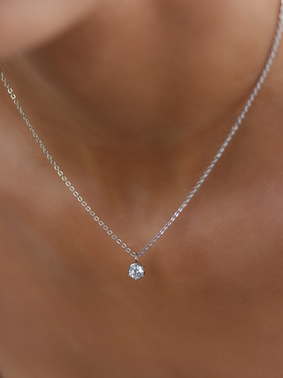 Close up of Luna necklace in white gold plating featuring solitaire cubic zirconia pendant