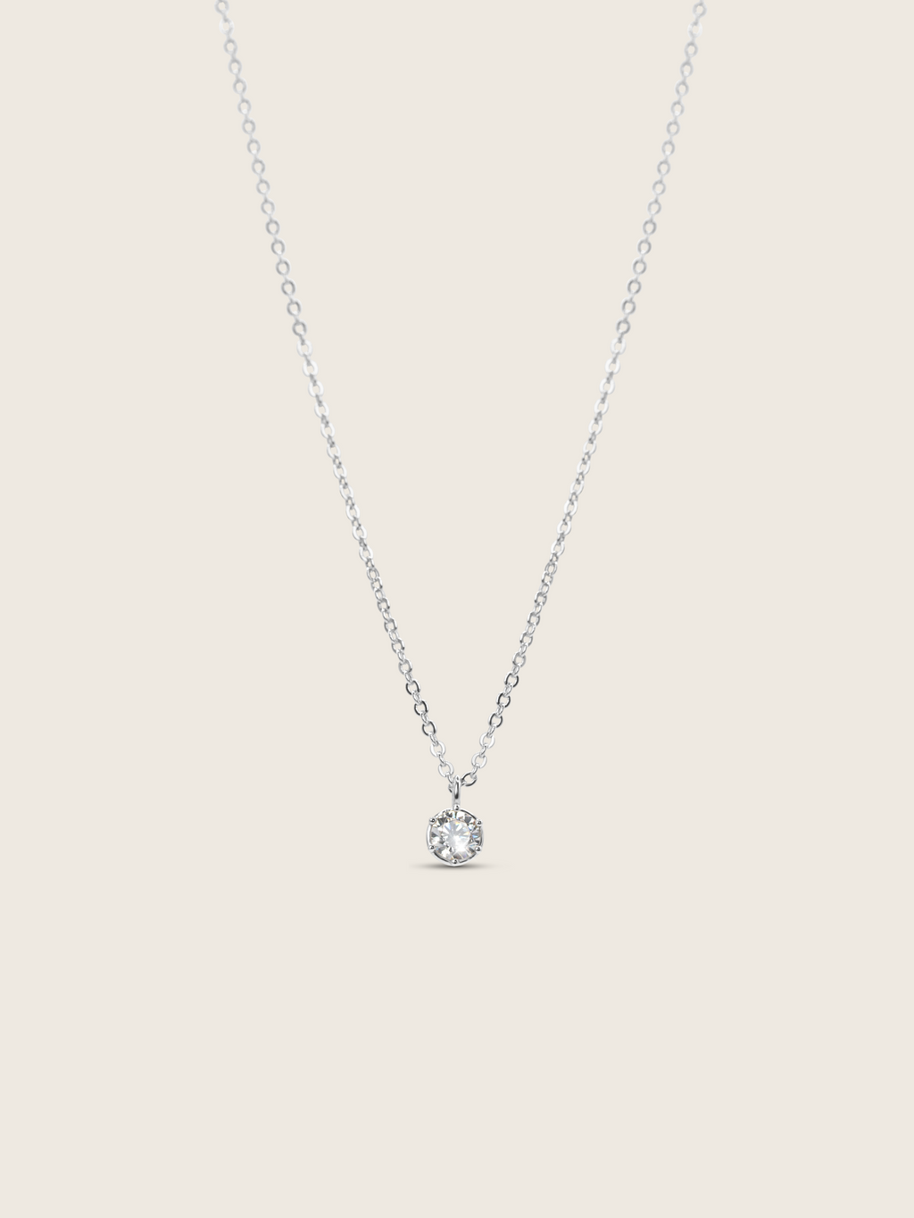 Luna necklace with premium white gold plating and solitaire cubic zirconia pendant, flat lay on white background