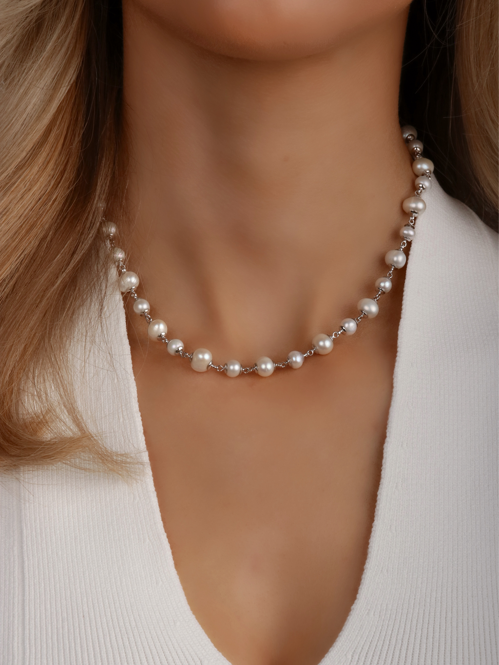 Close-up of White Gold-plated Margot pearl necklace with alternating freshwater pearls worn with white top
