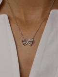 Meredith Bow Necklace in premium White Gold plating with crystal pavé bow pendant, worn on model with white blouse