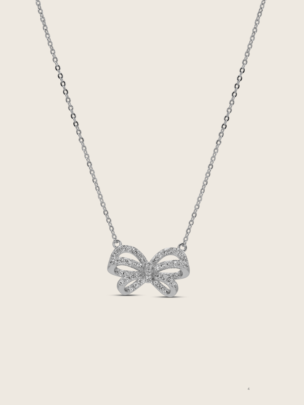 Meredith Bow Necklace in premium White Gold plating with crystal pavé bow on fine chain, displayed on neutral background