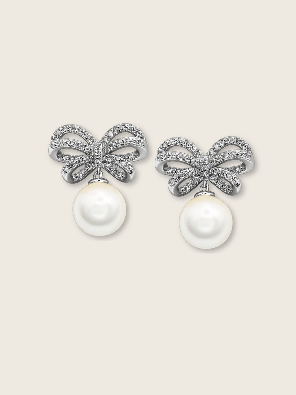 White background product image of white gold bow earrings with shell pearl drop