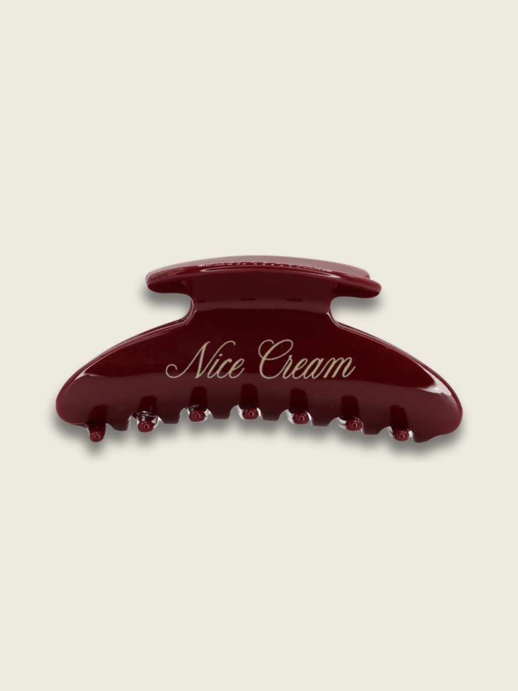 Flat-lay of a merlot claw hair clip on white background featuring brand name, showcasing affordable luxury and timeless British elegance.