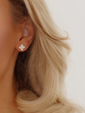 Gold plated Mini Hydrangea stud earring worn by model, showing a dainty pavé floral design against blonde hair and soft lighting