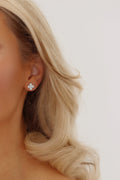 Mini Hydrangea stud earrings in White Gold plating worn by model with blonde hair, shown from a side profile to highlight floral shape and size