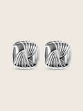 Flatlay of the Miranda earrings, featuring bold sculptural curves in high-polish sterling silver with white gold plating, designed with an 80s-inspired silhouette for a statement-making accessory.