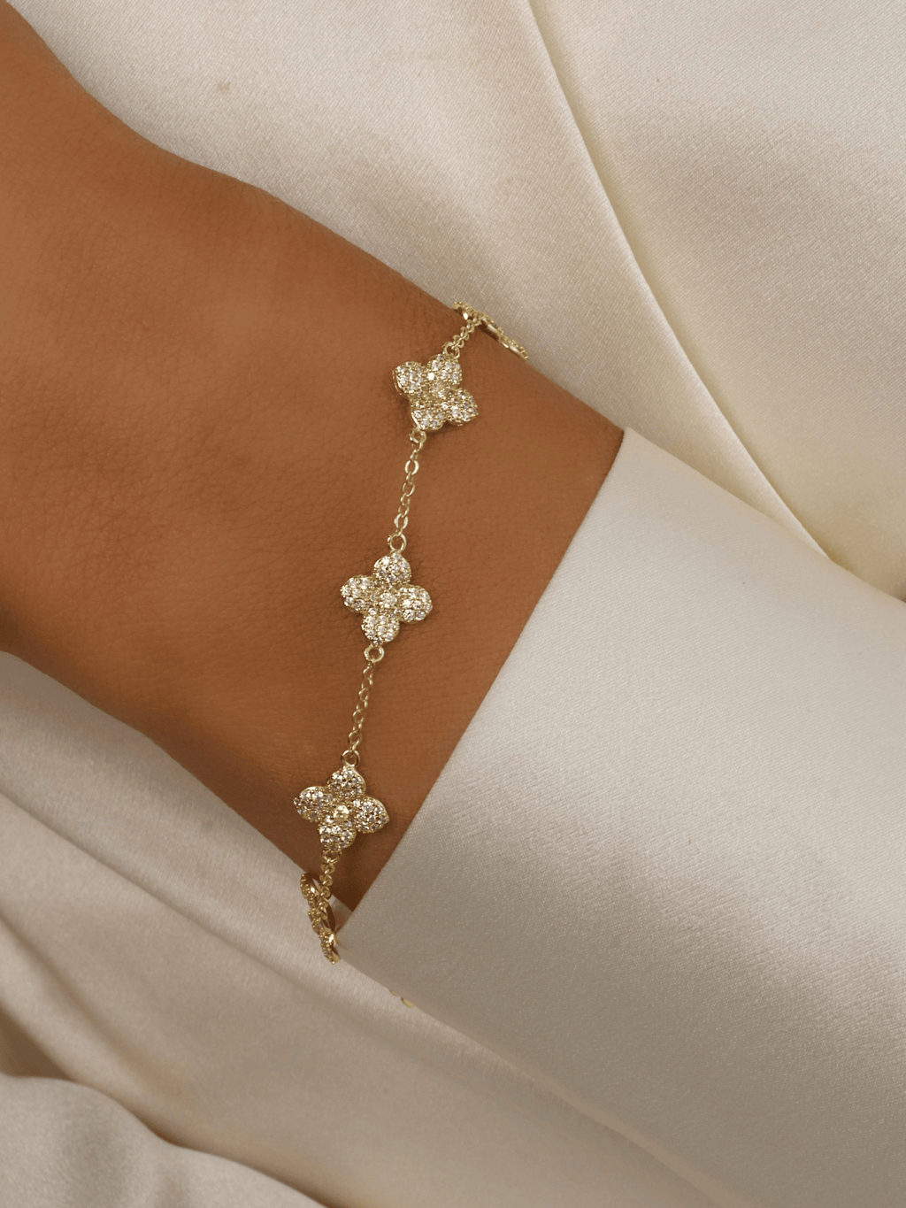 Multi Mini Lemon Drop Hydrangea bracelet in 14k Gold plating on model’s wrist, featuring lemon CZ flowers linked along an adjustable chain