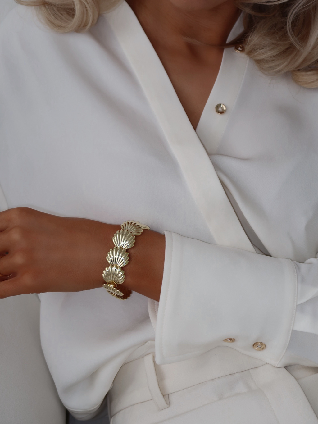 Muriel bracelet featuring linked shell motifs in 14k gold plating, worn on wrist