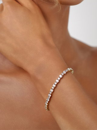 Nova tennis bracelet in 14k gold plating with cubic zirconia row shown on model wrist