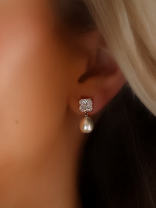 Close-up of the PEARLA earrings, featuring luminous freshwater pearls paired with square-cut CZ stones set in white gold-plated sterling silver. Timeless elegance perfect for both work and evening wear.