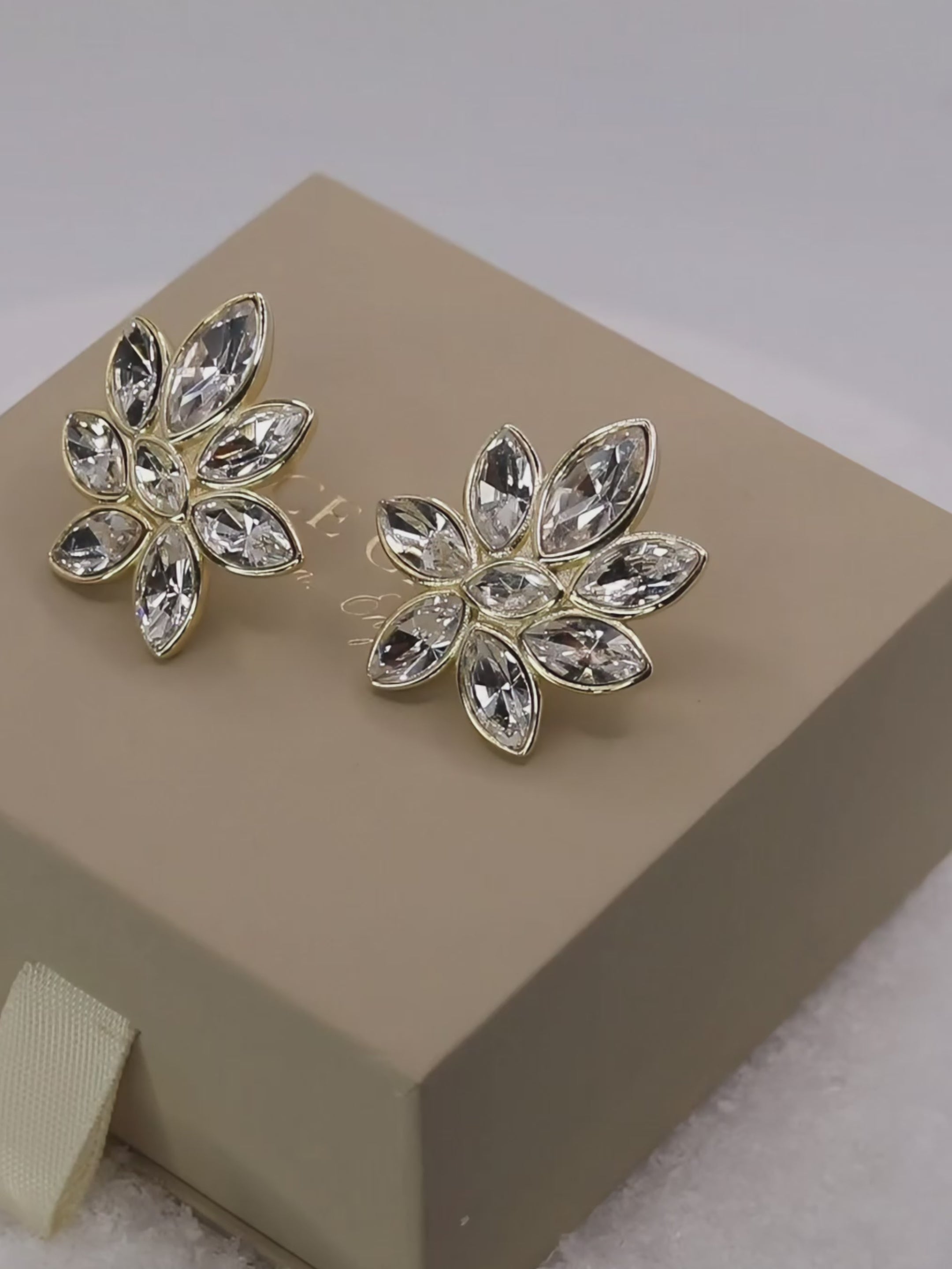 Iris Earrings in 14k gold plating with clear marquise cut cubic zirconia stones in floral design, revolving on neutral background to show sparkle from every angle
