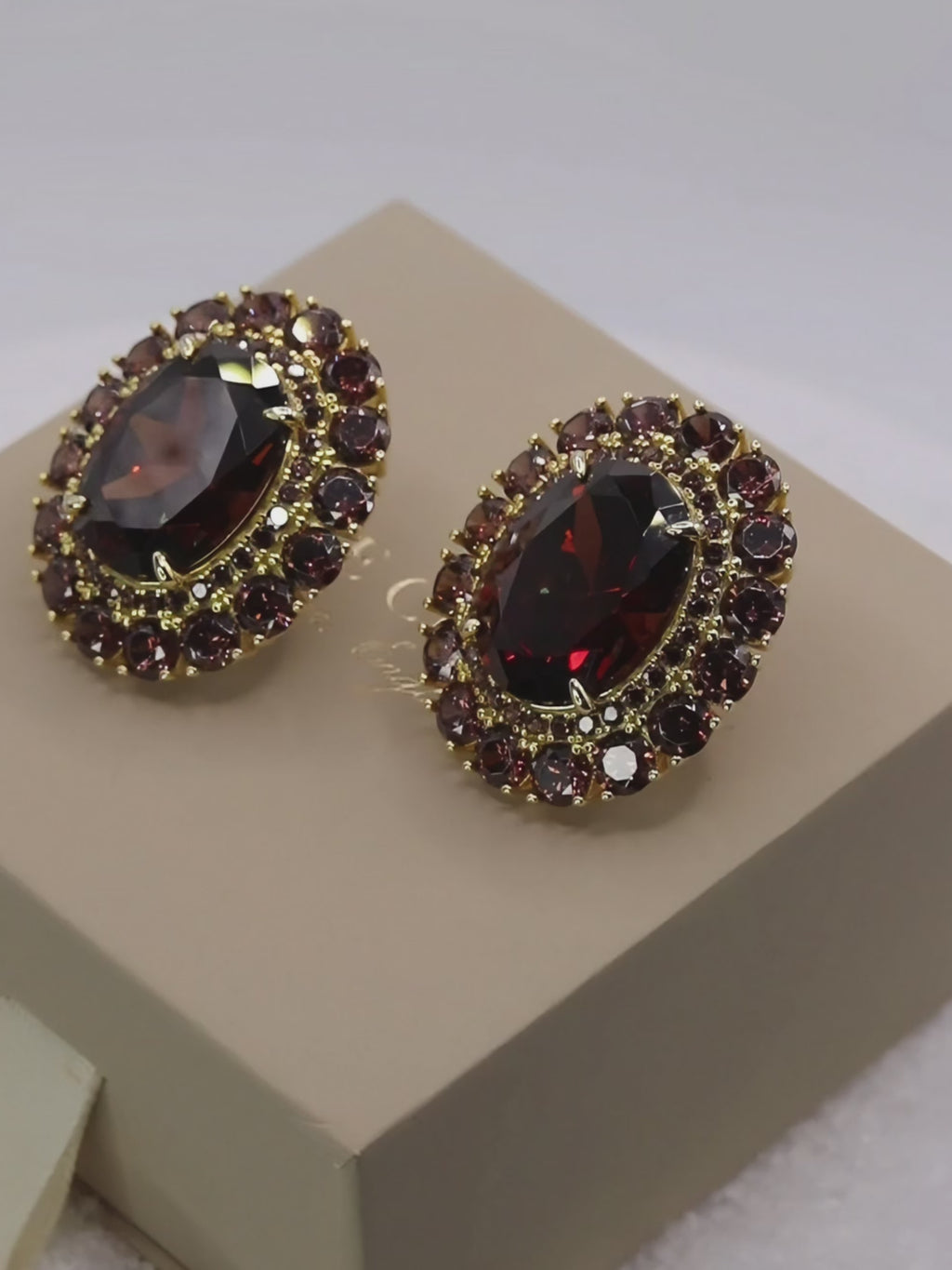 Video showcasing the sparkle and rich tone of the Diana earrings with wine-coloured cubic zirconia on product packaging