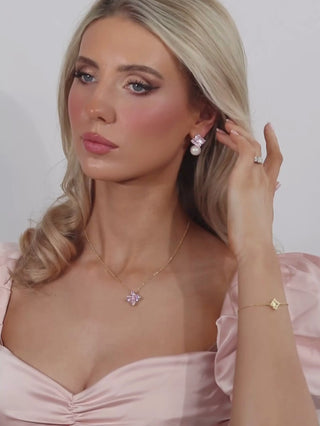 model wearing the crystal hydrangea earrings and necklace in blush with a pink dress and white background, showing the sparkle and light play
