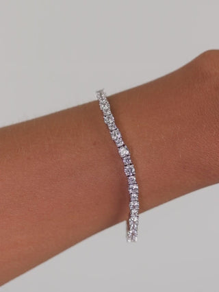 Nova tennis bracelet in premium white gold plating with continuous row of cubic zirconia stones shown on model wrist
