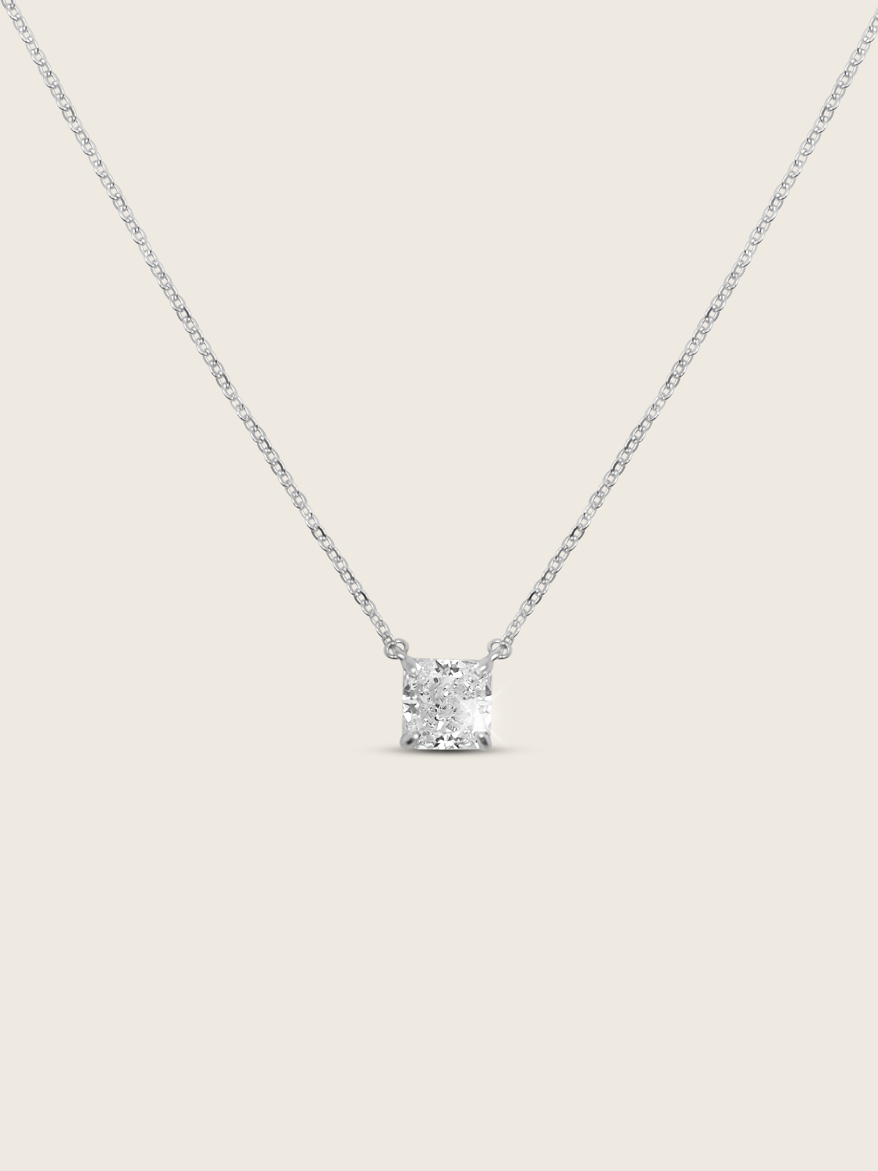 Regina necklace featuring a precisely cut square CZ stone set on a delicate sterling silver and white gold plated chain, displayed flat-lay on a white background to depict it's sparkle