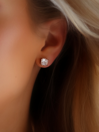Close-up of the Regina stud earrings featuring a perfectly cut square CZ stone set in white gold-plated sterling silver, worn on the model’s ear for a sophisticated, modern look that adds a touch of luxury to any ensemble.