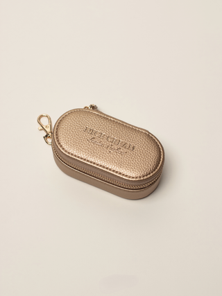 Closed small champagne jewellery case with gold zip and clasp, embossed Nice Cream London logo on the lid.