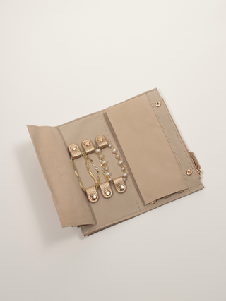 Champagne travel jewellery insert laid flat showing bracelet holders and zipped compartment.