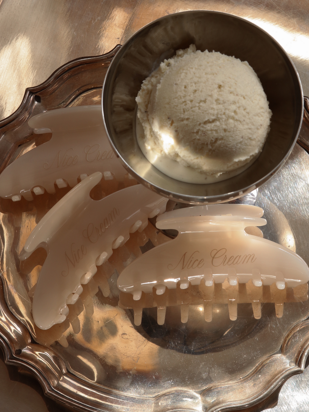 Vanilla claw hair clips arranged elegantly on a silver tray, paired with a scoop of vanilla ice cream for a playful, luxurious vibe. Perfect for everyday styling with a dash of indulgence.