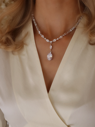 White gold plated Bridget necklace with oval and marquise-cut CZ stones and large central drop, styled against a soft cream neckline for timeless glamour