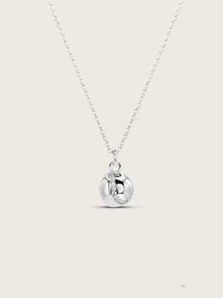 White gold plated tennis ball necklace with a seam of pavé CZ stones on a fine chain