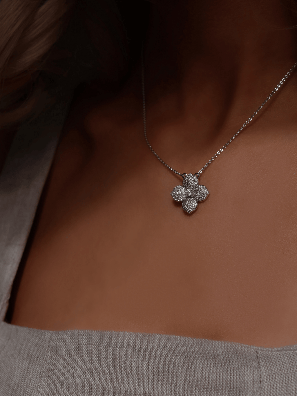 White gold hydrangea flower necklace with CZ stones worn with a soft square neckline for a feminine summer look